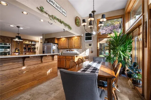 a living room with dining room furniture and a chandelier