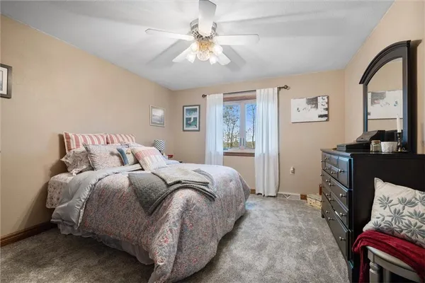 a spacious bedroom with a bed a couch and a chandelier