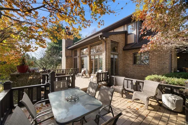 a view of a patio with a dining table and chairs with couches potted plants and a barbeque