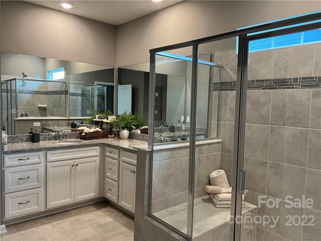 4027 Havenport Circle, Unit 121 Tega Cay, SC 29708 - Photo 15 of 24 a bathroom with a double vanity sink and mirror