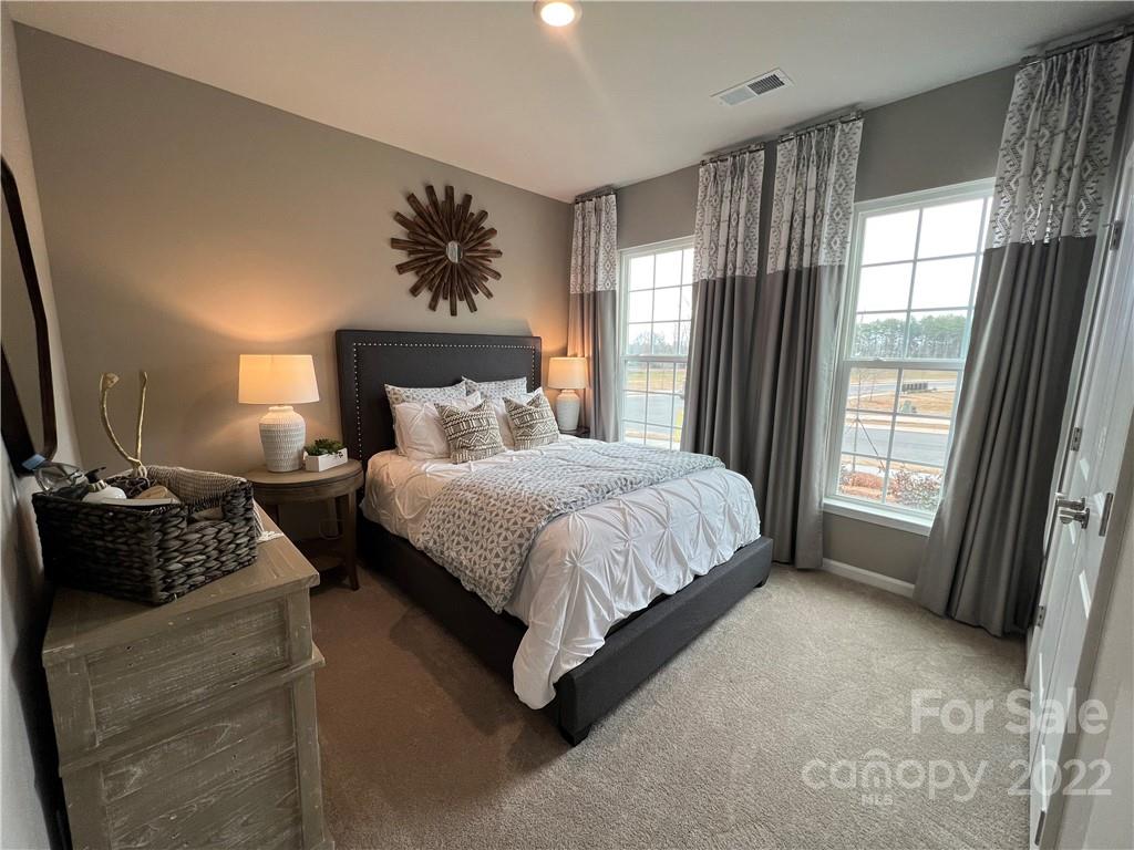 4027 Havenport Circle, Unit 121 Tega Cay, SC 29708 - Photo 18 of 24 a bed sitting in a bedroom next to a window