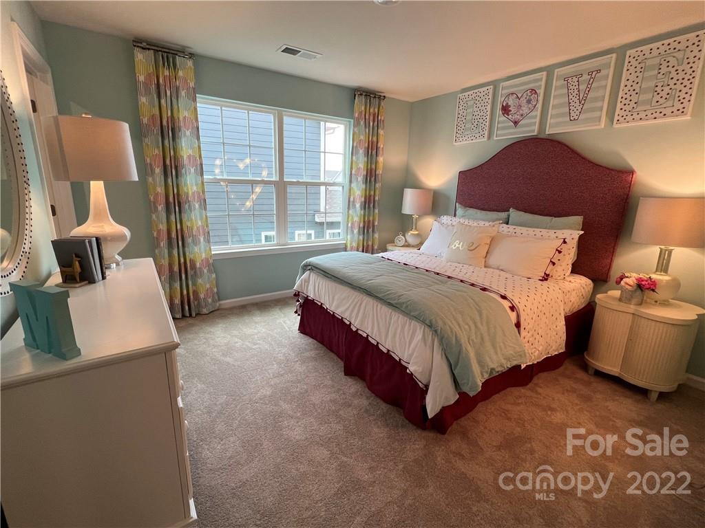 4027 Havenport Circle, Unit 121 Tega Cay, SC 29708 - Photo 23 of 24 a spacious bedroom with a bed and wooden floor