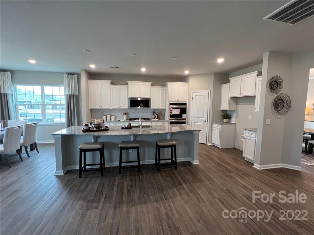 4027 Havenport Circle, Unit 121 Tega Cay, SC 29708 - Photo 6 of 24 a open kitchen with stainless steel appliances granite countertop a refrigerator and a stove top oven