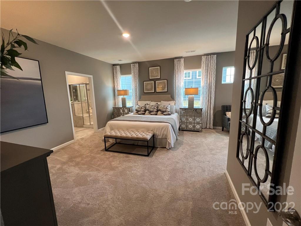 4027 Havenport Circle, Unit 121 Tega Cay, SC 29708 - Photo 10 of 24 a bedroom with a bed and dresser with mirror