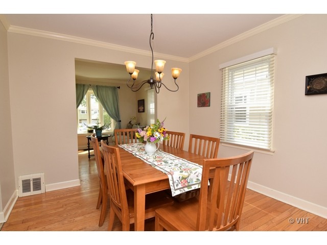 924 Spring Road Elmhurst, IL 60126 - Photo 4 of 18 a dining room with furniture a chandelier and wooden floor