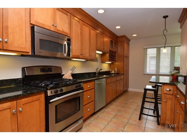 924 Spring Road Elmhurst, IL 60126 - Photo 5 of 18 a kitchen with stainless steel appliances granite countertop a stove a sink and a microwave