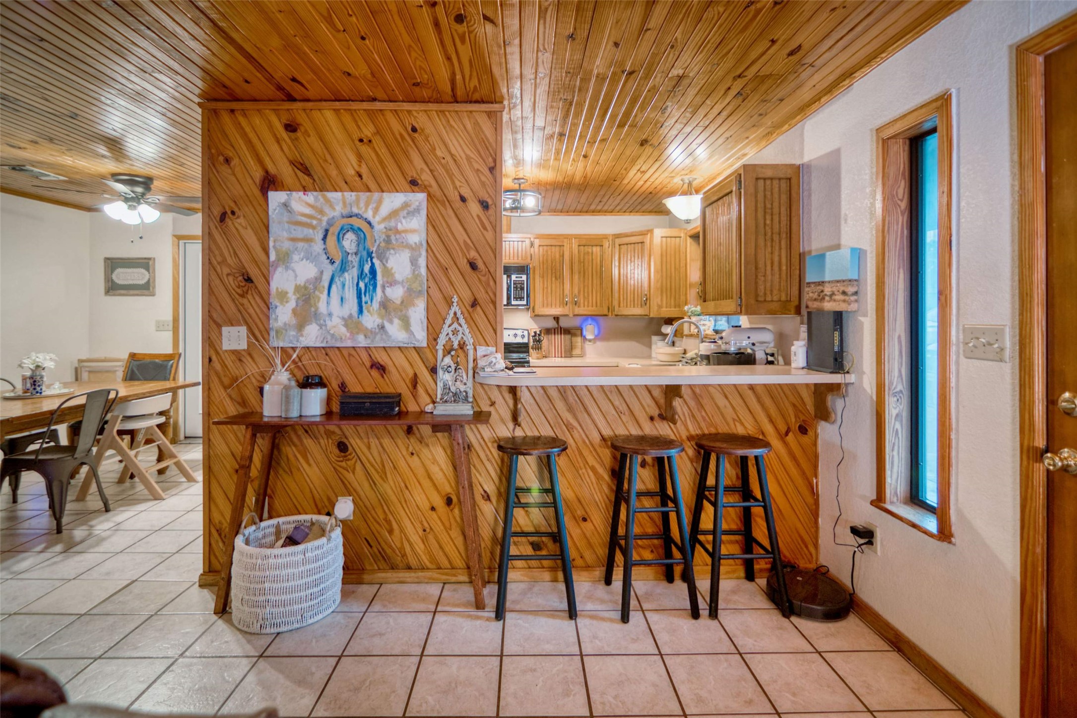 904 Bluebonnet Road Mason, TX 76856 - Photo 8 of 28 Kitchen with a wood-paneled breakfast bar, light wood cabinetry, and a ceiling fan
