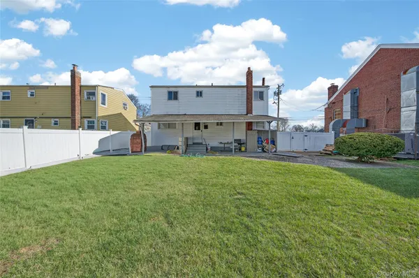 a view of a house with a big yard and large trees