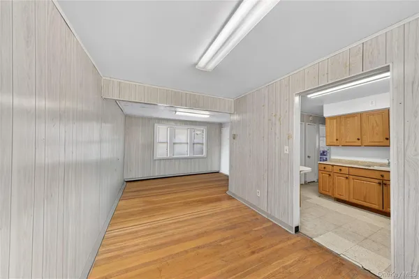 a view of a room with wooden floor and electronic appliances