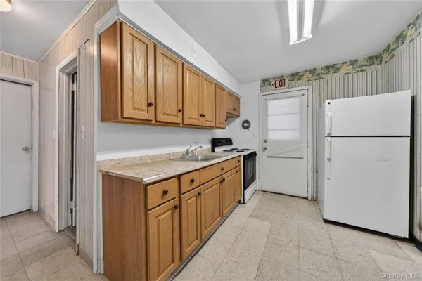 a kitchen with granite countertop a refrigerator a sink and dishwasher