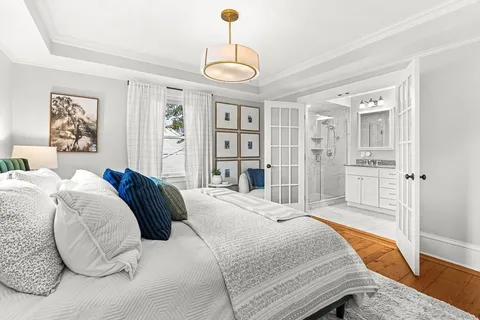 a bedroom with a large bed and a chandelier