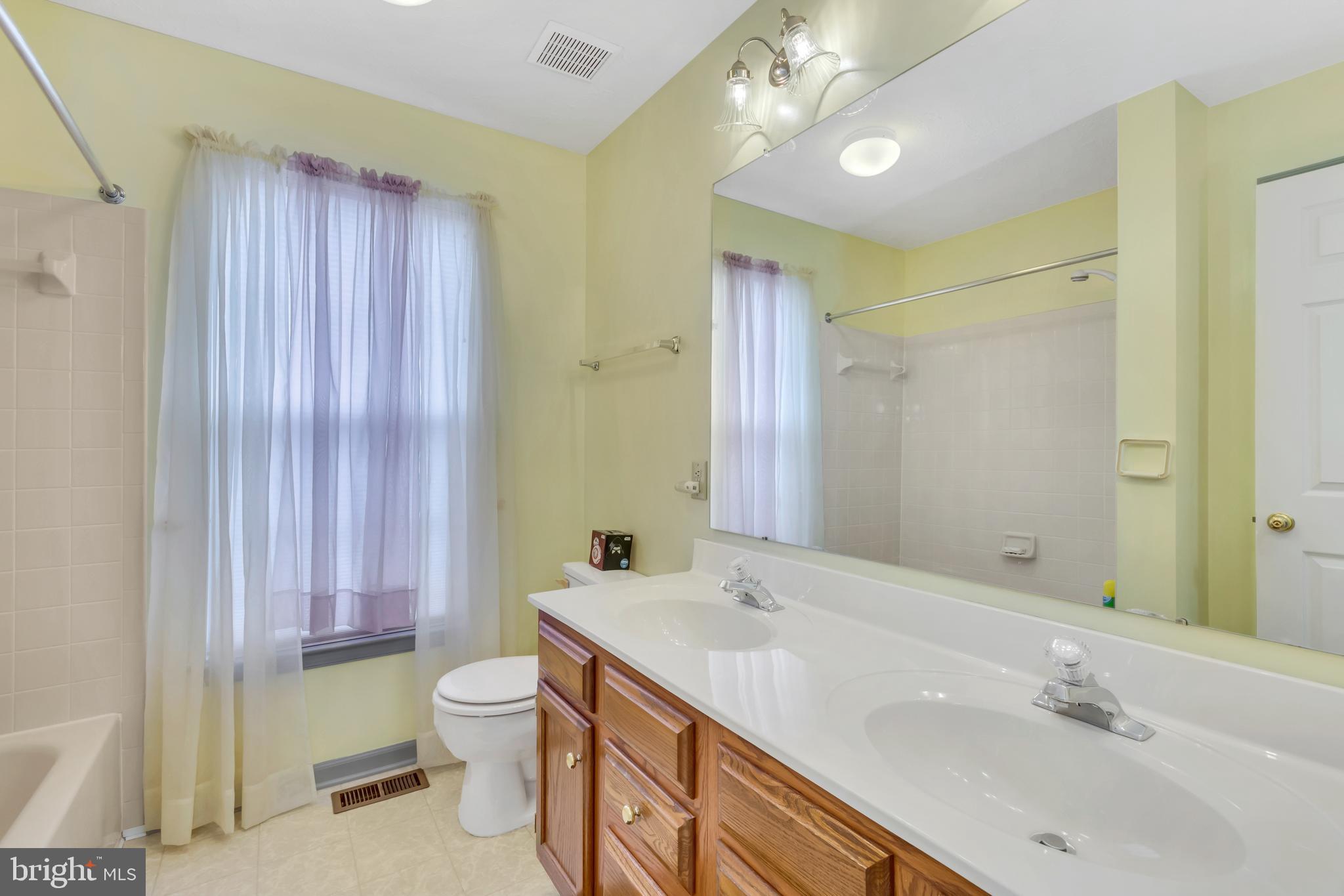 2908 Garwood Road Sicklerville, NJ 08081 - Photo 21 of 25 a bathroom with a double vanity sink toilet and a mirror