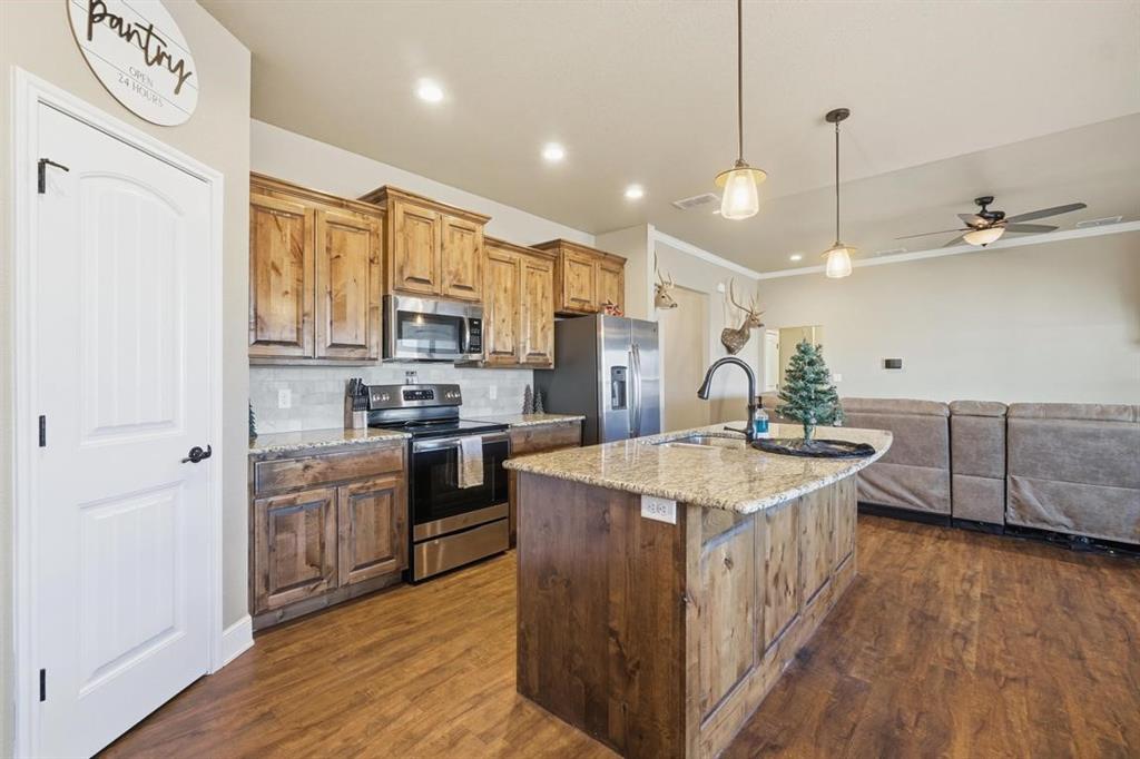 7414 Morning Glory Road Abilene, TX 79602 - Photo 33 of 34 a kitchen with stainless steel appliances granite countertop a sink a stove and a refrigerator