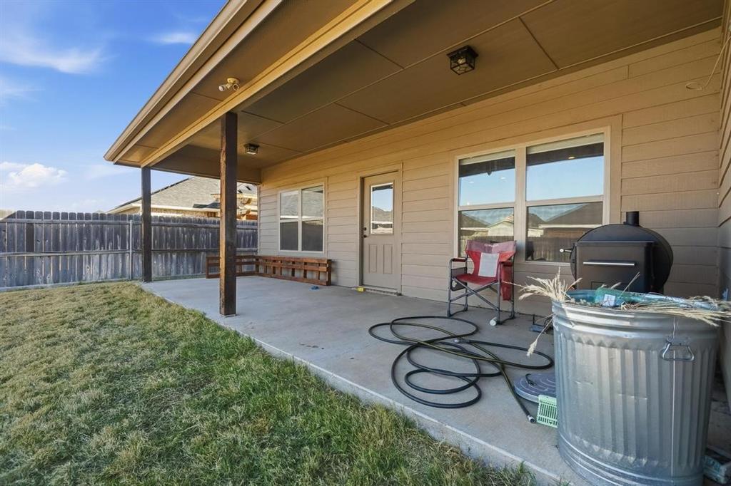 7414 Morning Glory Road Abilene, TX 79602 - Photo 4 of 34 a view of a patio with table and chairs under an umbrella