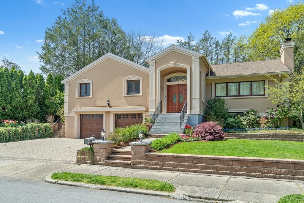 a front view of a house with a yard and potted plants
