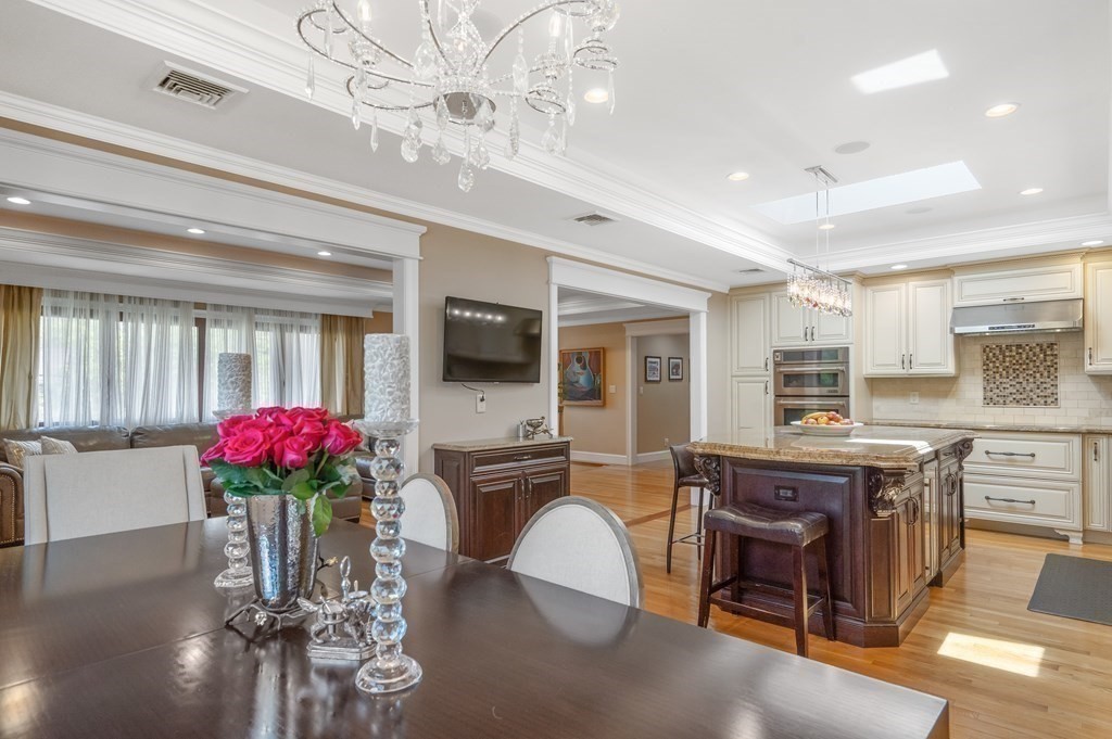 113 Deborah Road Newton, MA 02459 - Photo 12 of 34 a dining room with furniture potted plants and wooden floor