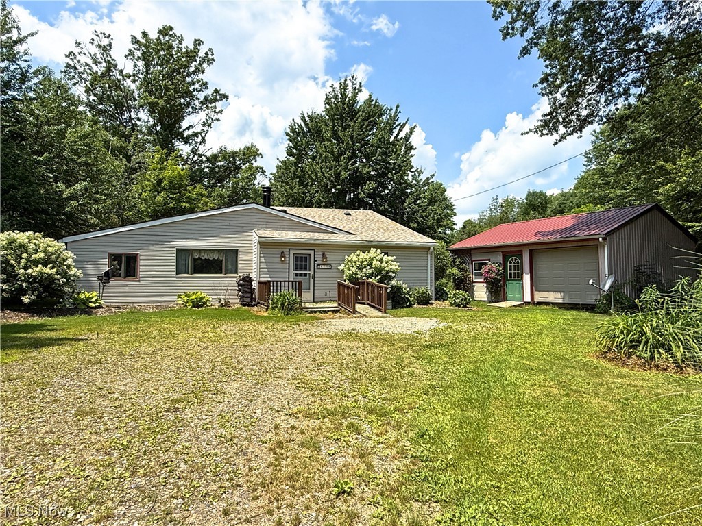 8756 Cook Road Salem, OH 44460 - Photo 4 of 50 Back of house featuring a yard and an outbuilding