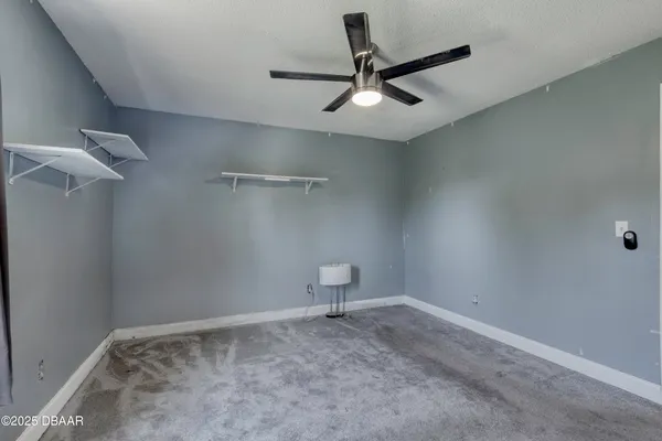 an empty room with a view of a ceiling fan and a window