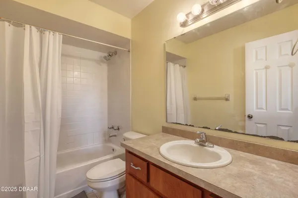 a bathroom with a granite countertop sink toilet a mirror and shower