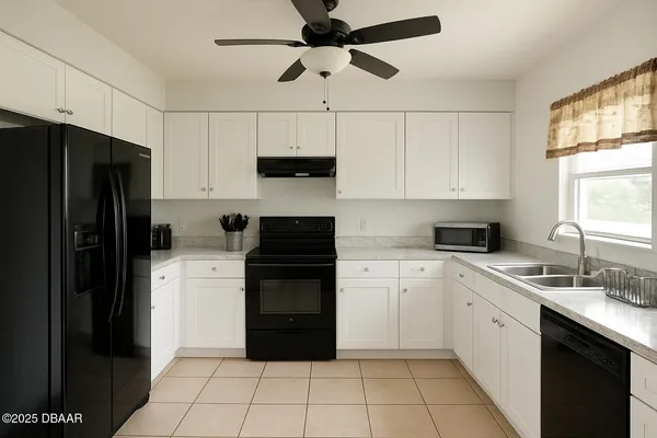 a kitchen with a sink a refrigerator and white cabinets
