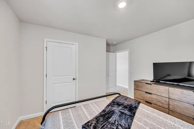 a bedroom with bed and flat screen tv