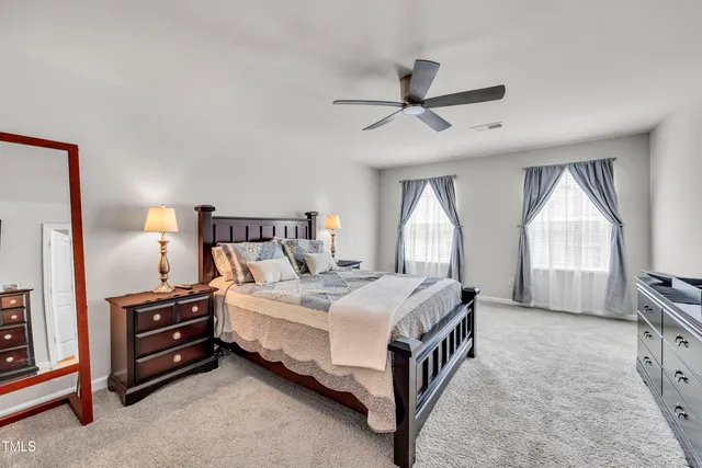 a bedroom with a bed a chandelier and a large window