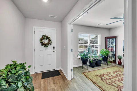 a view of a hallway with wooden floor and a potted plant