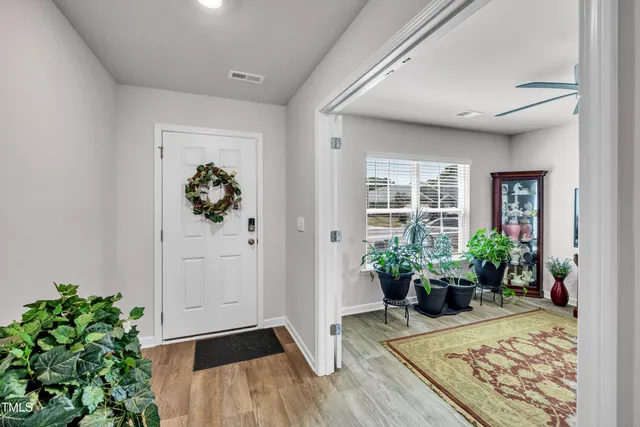 a view of a hallway with wooden floor and a potted plant