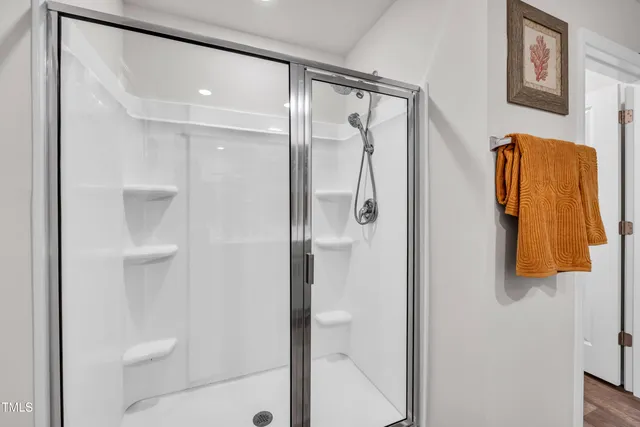 a bathroom with a shower and a glass door