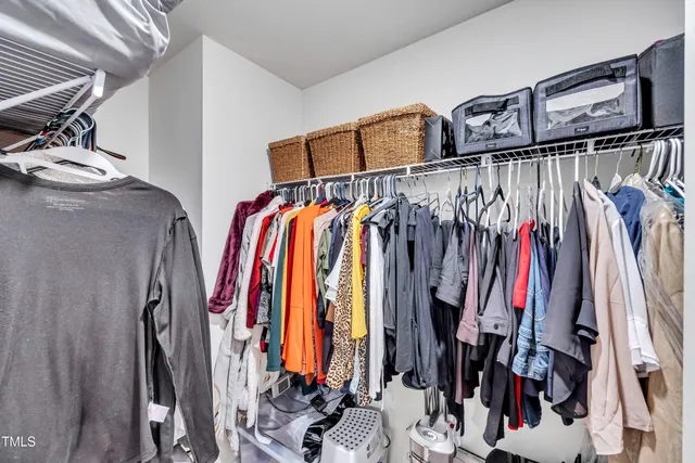 a view of walk in closet with clothes