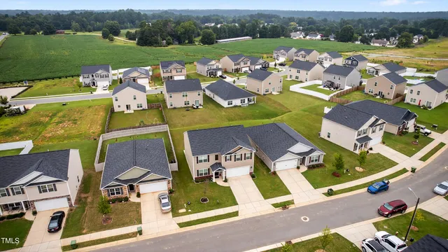 an aerial view of residential houses with outdoor space and river
