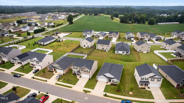 an aerial view of residential houses with outdoor space and river