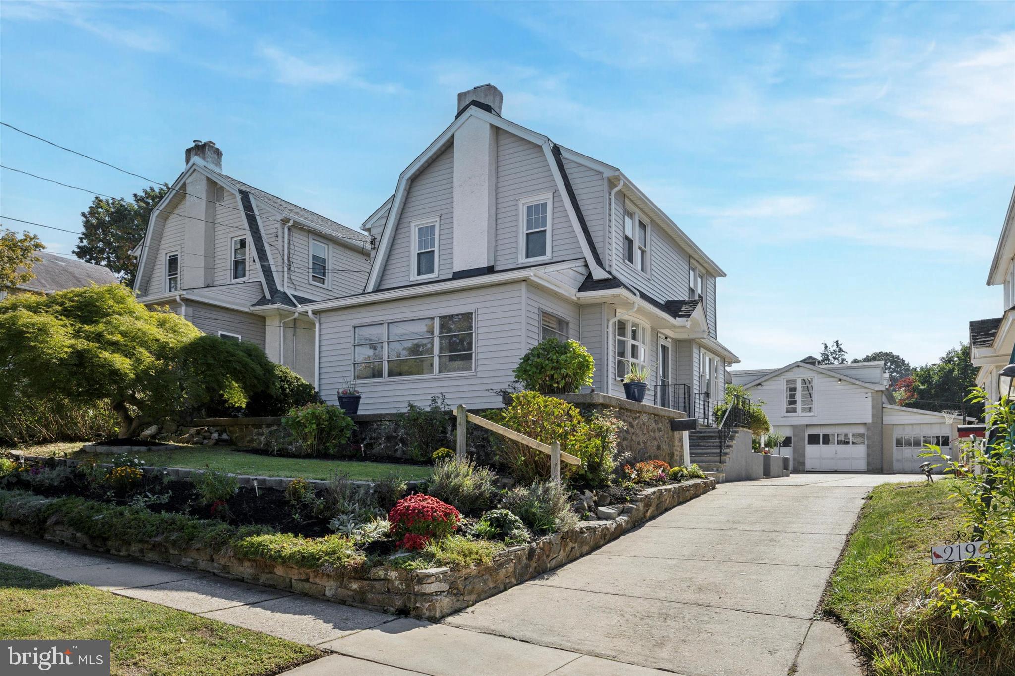 a front view of a house with a garden and plants