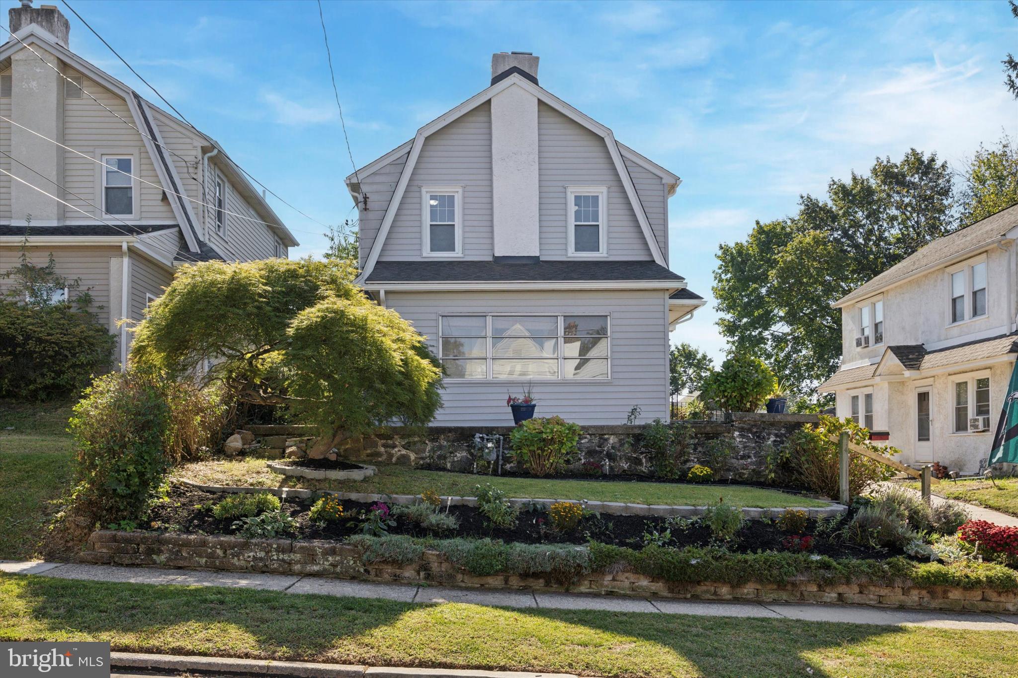 217 Windsor Avenue Upper Darby, PA 19082 - Photo 2 of 36 a front view of a house with a yard and potted plants