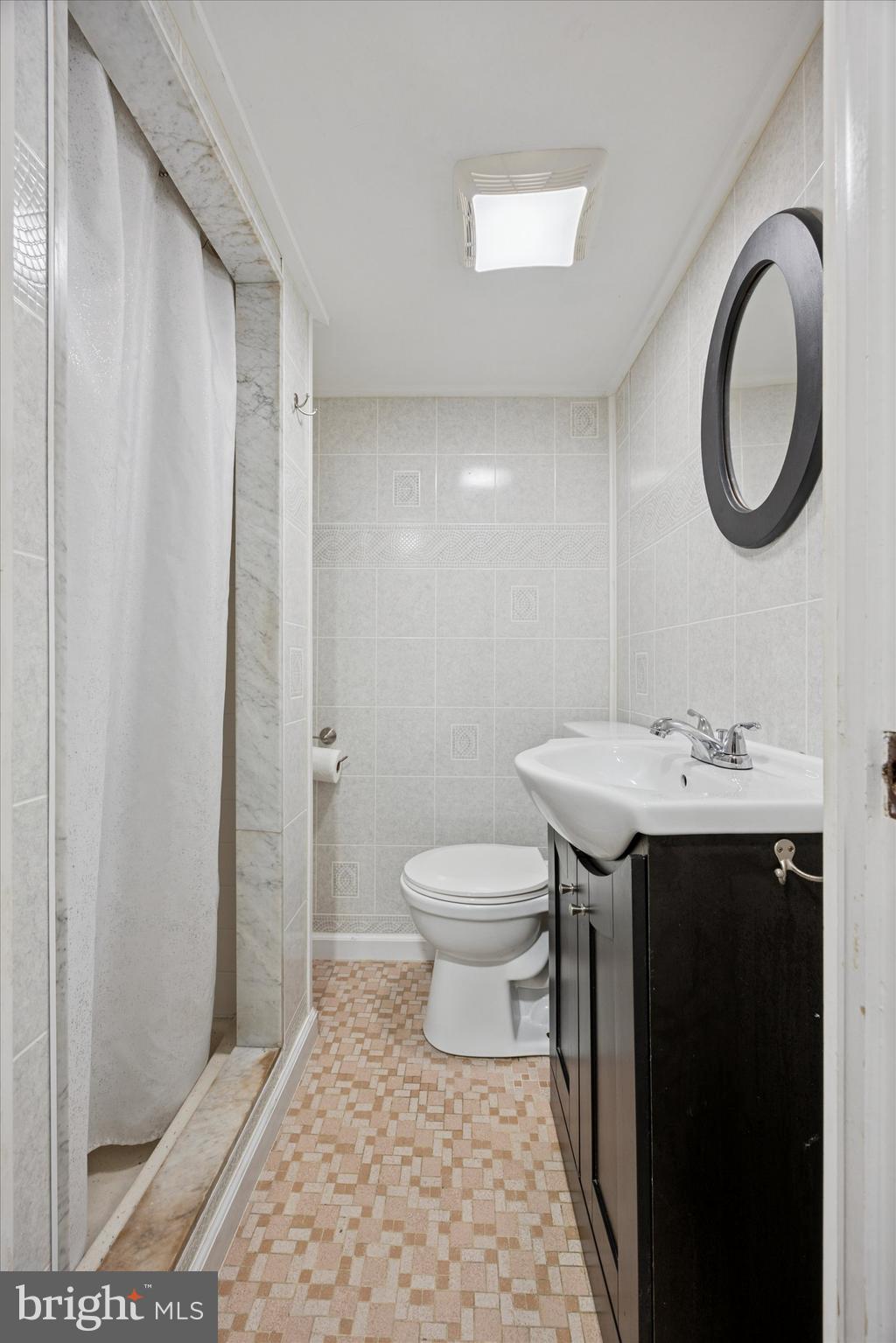 217 Windsor Avenue Upper Darby, PA 19082 - Photo 24 of 36 a bathroom with a sink a toilet and a mirror