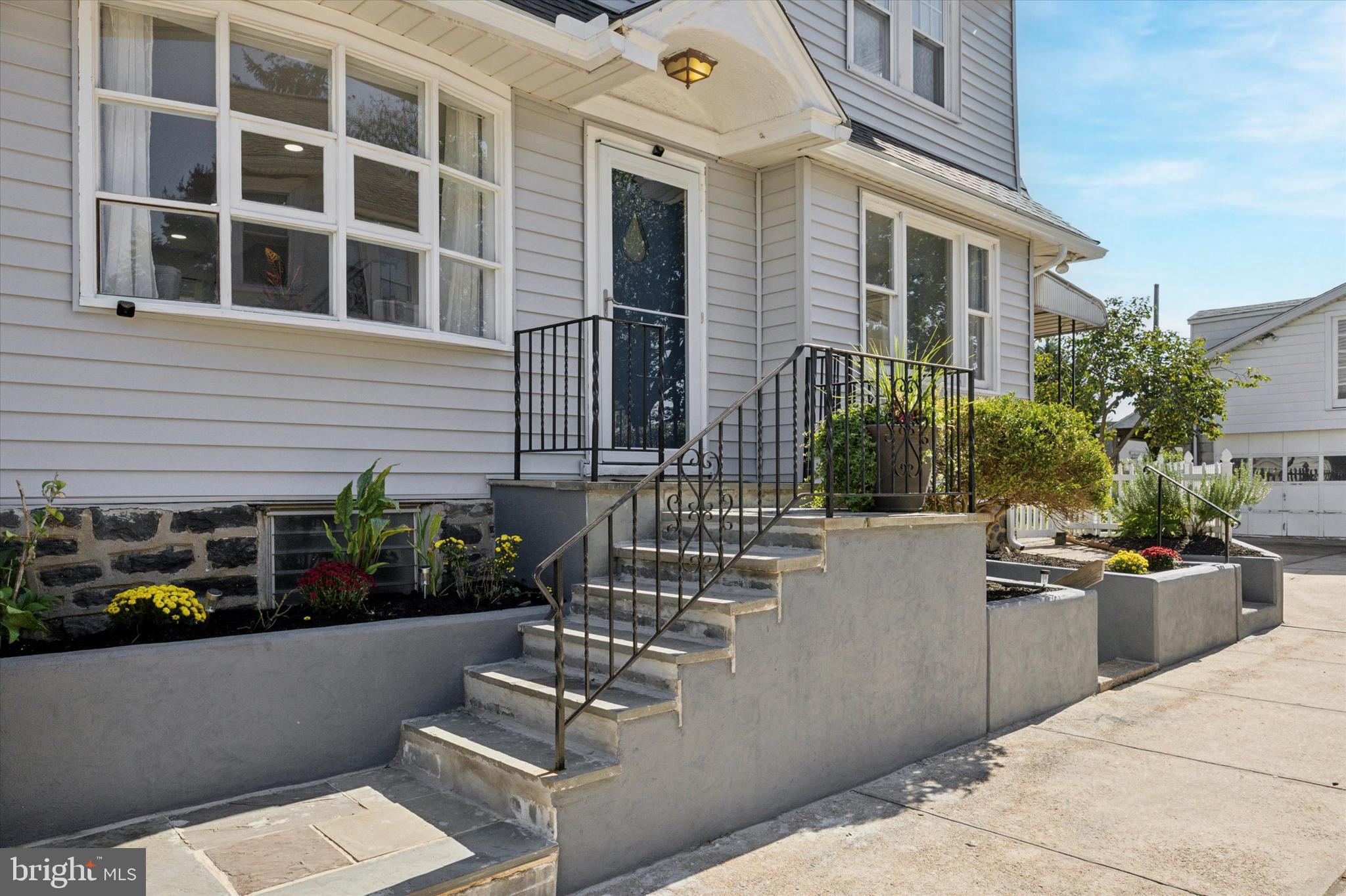 217 Windsor Avenue Upper Darby, PA 19082 - Photo 3 of 36 a view of a building with potted plants and a fountain