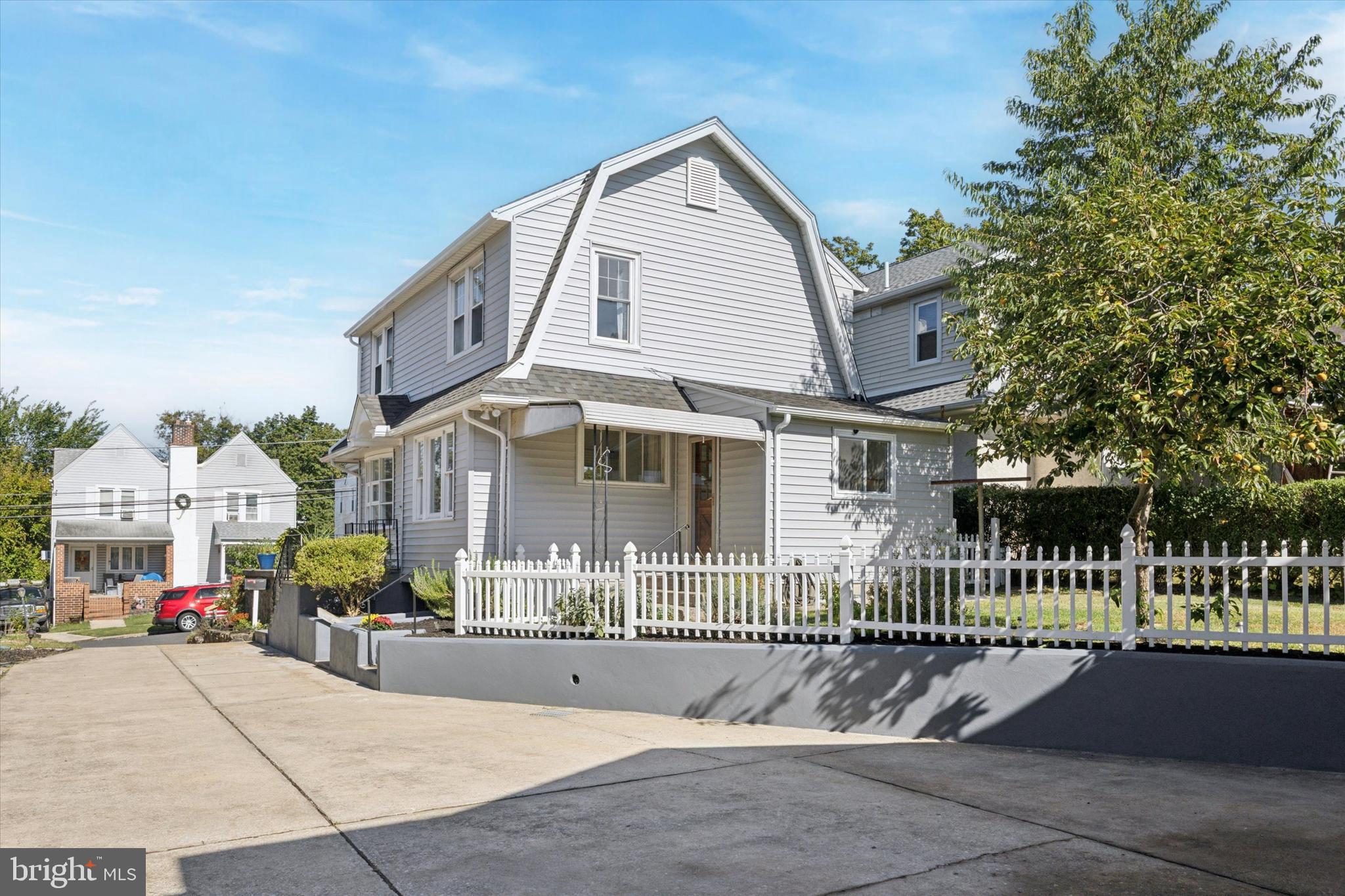 217 Windsor Avenue Upper Darby, PA 19082 - Photo 35 of 36 a view of a brick house with a small yard and a large tree