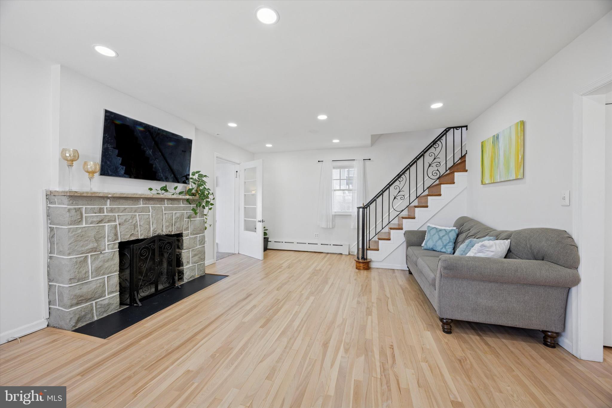 217 Windsor Avenue Upper Darby, PA 19082 - Photo 4 of 36 a living room with furniture a fireplace and a flat screen tv