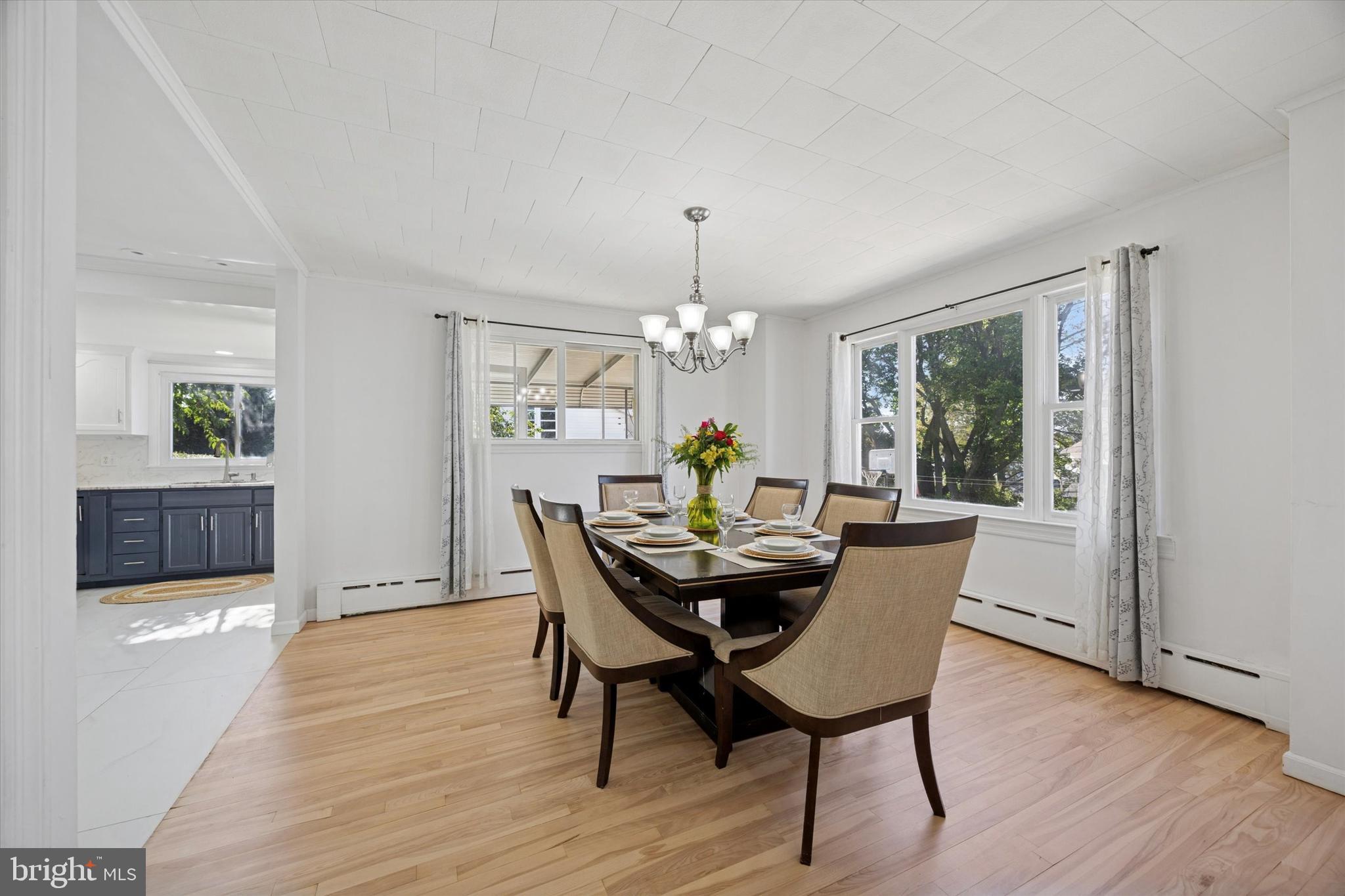 217 Windsor Avenue Upper Darby, PA 19082 - Photo 9 of 36 a dining room with furniture a chandelier and wooden floor