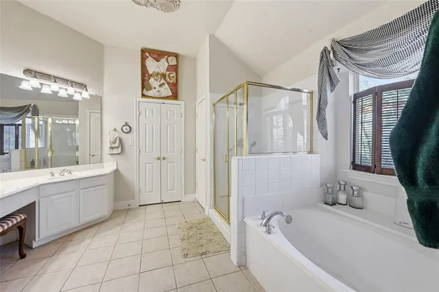 a bathroom with a tub a sink and a large mirror