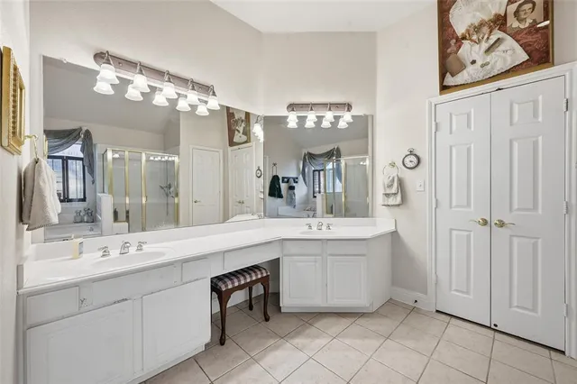 a spacious bathroom with a double vanity sink mirror and bathtub