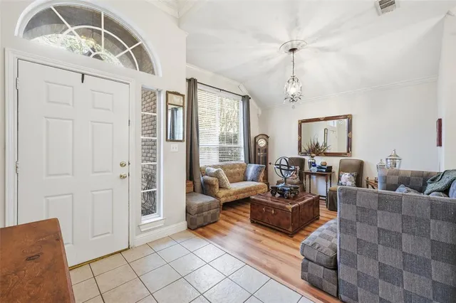 a living room with furniture and a chandelier