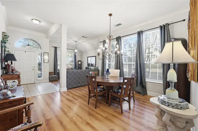 a dining room with furniture a chandelier and wooden floor