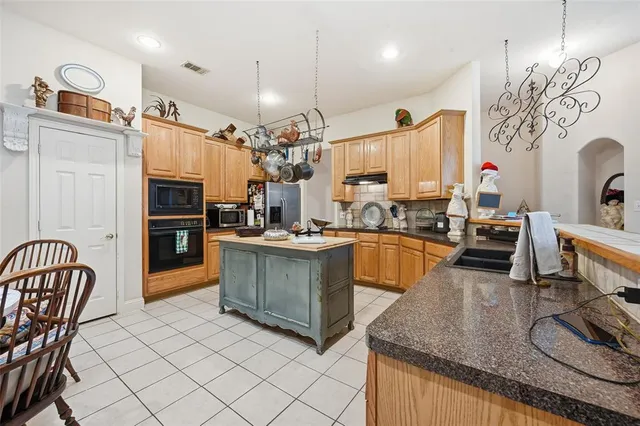 a kitchen with stainless steel appliances granite countertop a sink and a refrigerator