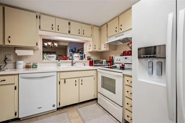 a kitchen with cabinets stainless steel appliances and white appliances