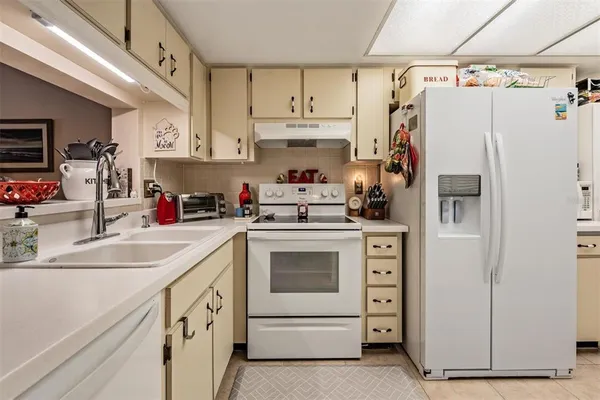 a kitchen with white cabinets and white appliances