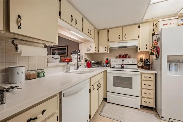 a kitchen with kitchen island white cabinets and white appliances