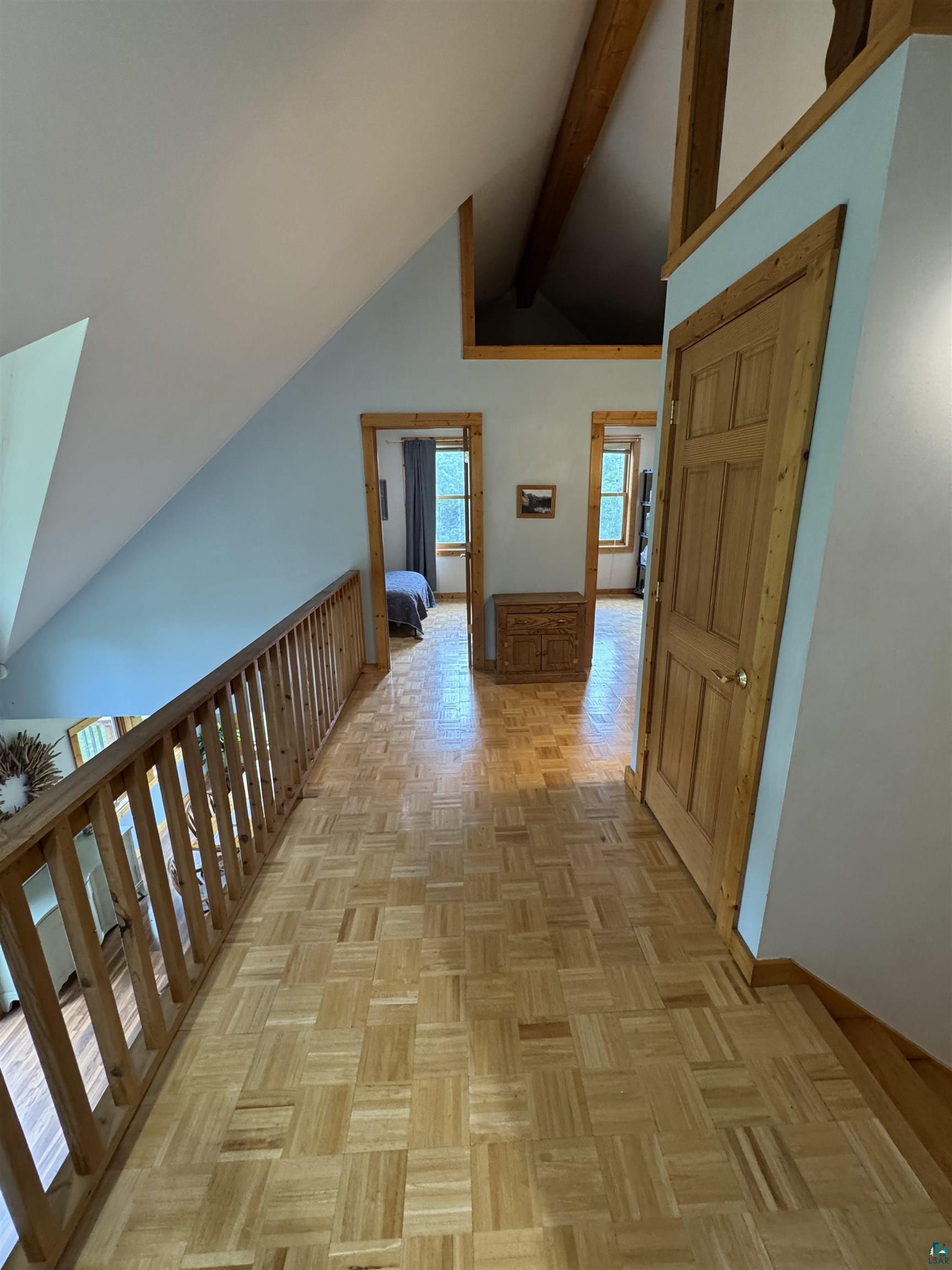 1745 Becks Road Maple, WI 54854 - Photo 21 of 46 Upper-level landing featuring wood-finish parquet flooring, natural wood doors, and trim