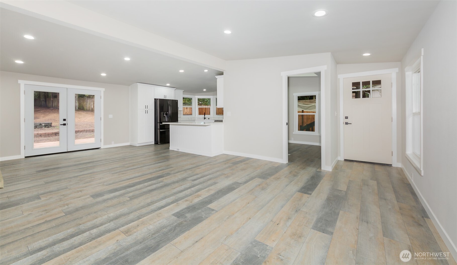 225 North Lake Roesiger Road Snohomish, WA 98290 - Photo 11 of 40 an empty room with wooden floor and kitchen view
