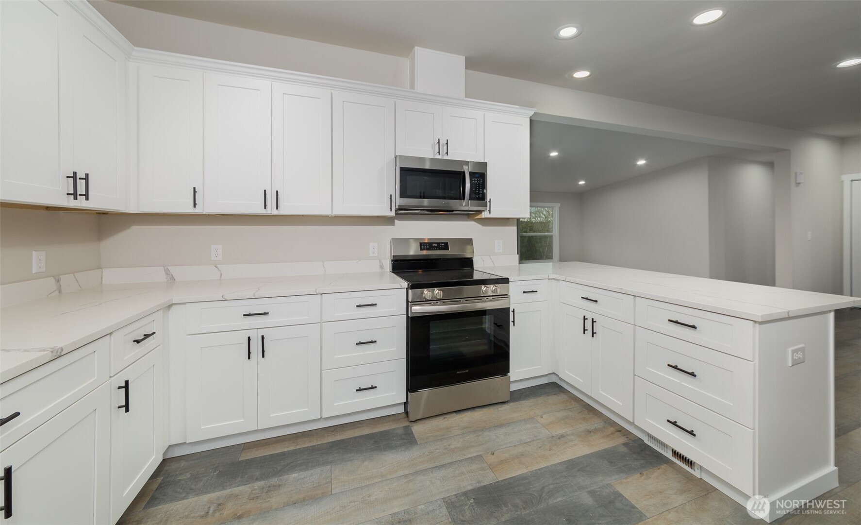 225 North Lake Roesiger Road Snohomish, WA 98290 - Photo 7 of 40 a kitchen with white cabinets and stainless steel appliances